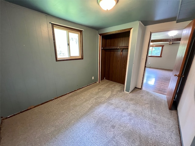 unfurnished bedroom featuring a closet and light colored carpet