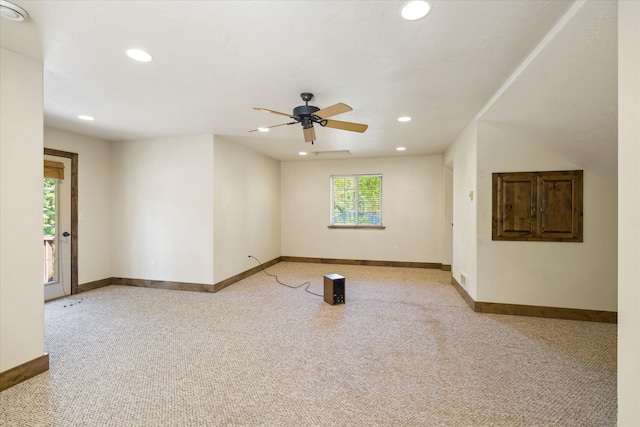 carpeted spare room featuring ceiling fan