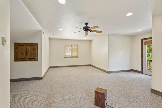 spare room with ceiling fan and light colored carpet