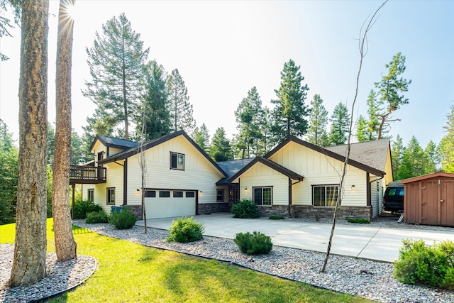 view of front of home with a storage unit, a front lawn, and a garage