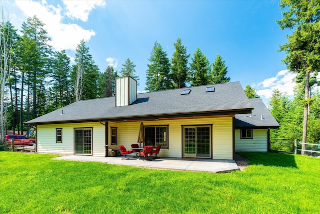 rear view of house featuring a yard and a patio