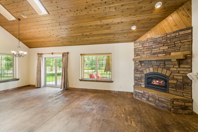 unfurnished living room with dark hardwood / wood-style floors, wood ceiling, a skylight, a fireplace, and a notable chandelier