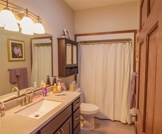 bathroom with hardwood / wood-style floors, toilet, and vanity