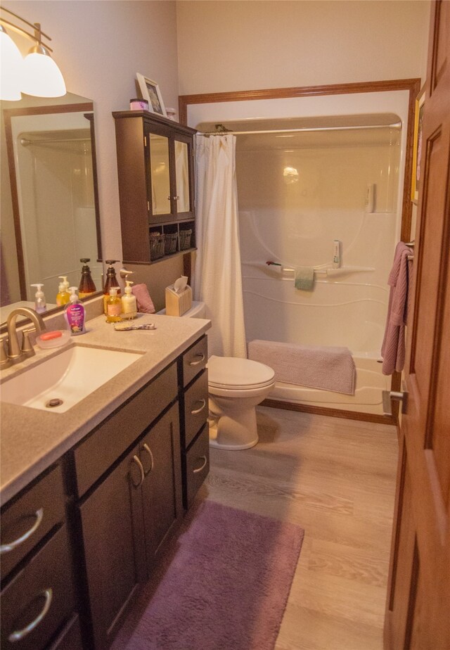 full bathroom with vanity, toilet, shower / bath combo with shower curtain, and hardwood / wood-style flooring