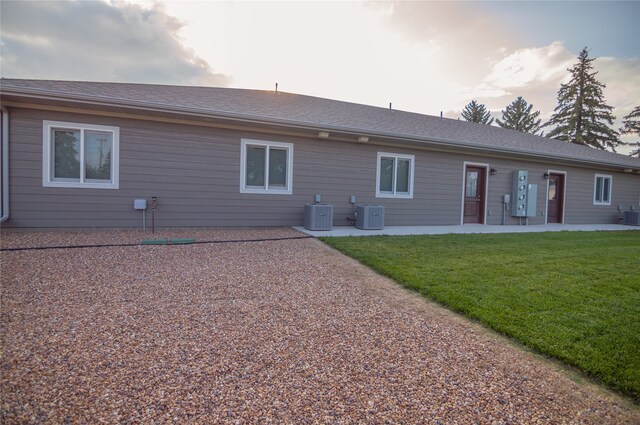 rear view of property featuring cooling unit, a patio area, and a yard