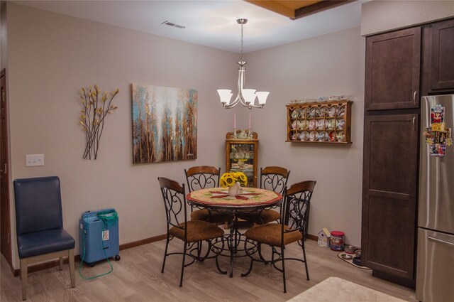 dining space featuring a notable chandelier and light hardwood / wood-style flooring