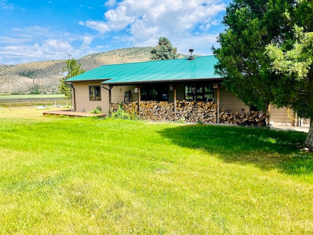 view of front facade featuring a front lawn and a mountain view