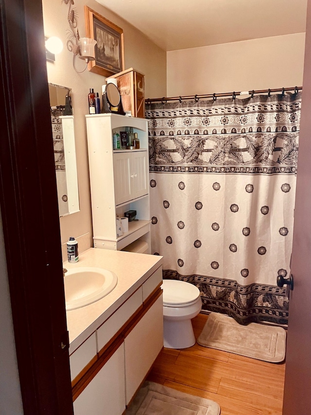 bathroom featuring vanity, hardwood / wood-style floors, and toilet