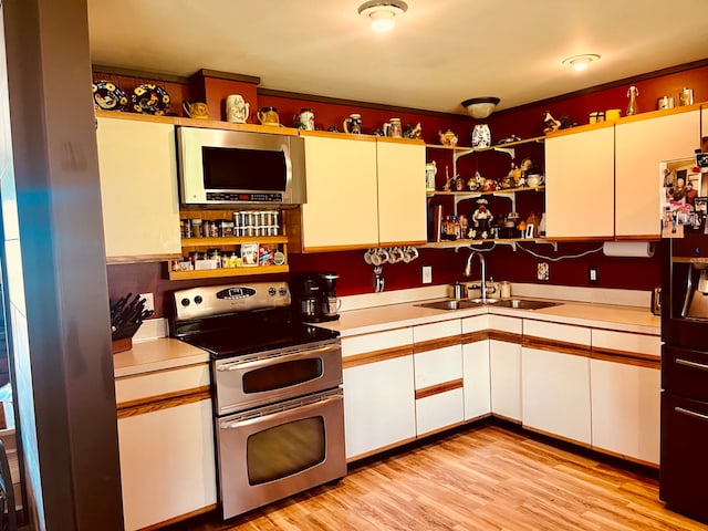 kitchen with white cabinetry, sink, appliances with stainless steel finishes, and light wood-type flooring