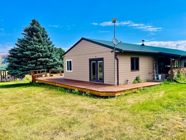 rear view of house featuring a yard and a wooden deck