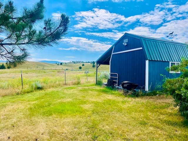 view of shed / structure featuring a rural view and a lawn