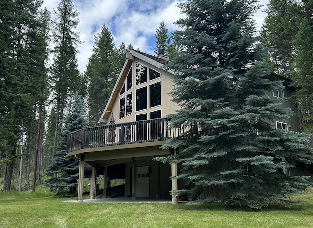 rear view of house with a wooden deck and a yard