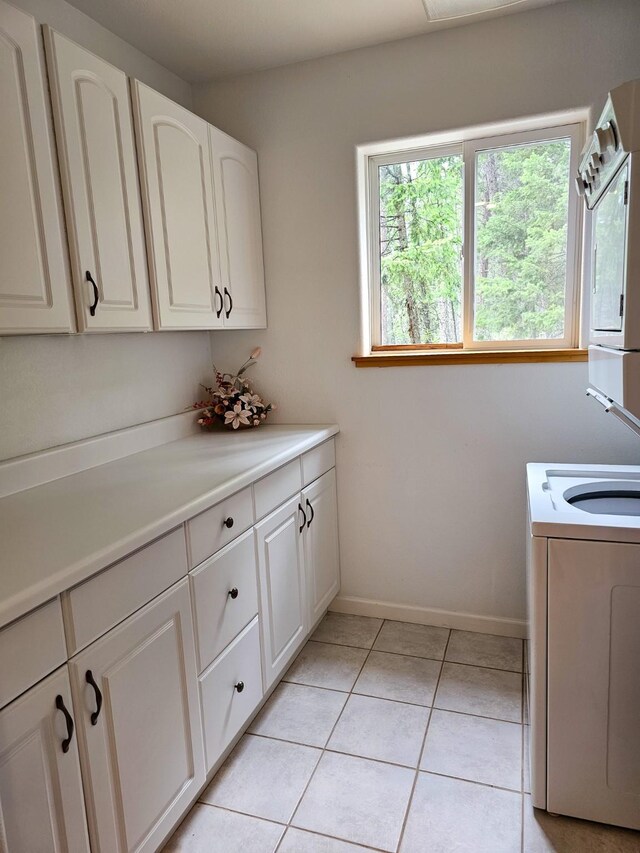 3971 Glen Lake Rd, Eureka, MT 59917 - laundry room with washer / clothes dryer, cabinet space, and light tile patterned floors