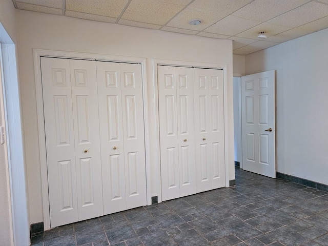 3971 Glen Lake Rd, Eureka, MT 59917 - unfurnished bedroom featuring two closets, a paneled ceiling, and dark stone finish flooring