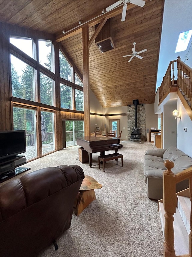 3971 Glen Lake Rd, Eureka, MT 59917 - carpeted living area featuring high vaulted ceiling, a wood stove, wooden ceiling, ceiling fan, and healthy amount of natural light