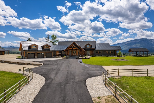 view of front facade with a garage, a front lawn, and a mountain view