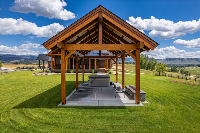 exterior space with a patio, a lawn, a mountain view, and a gazebo