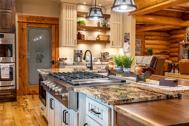 kitchen featuring decorative light fixtures, light wood-type flooring, rustic walls, beamed ceiling, and double oven