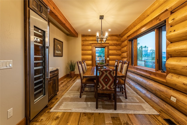 dining area featuring an inviting chandelier, wood-type flooring, and rustic walls