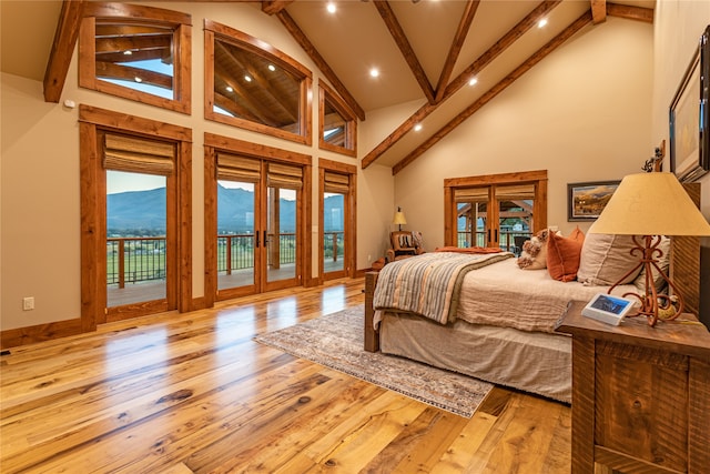 bedroom featuring high vaulted ceiling, light wood-type flooring, a mountain view, beamed ceiling, and access to exterior