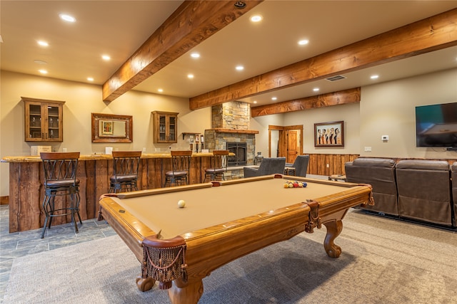 rec room featuring a stone fireplace, light colored carpet, indoor bar, beam ceiling, and billiards