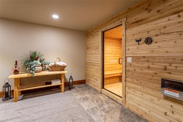 hall with tile patterned floors and wooden walls