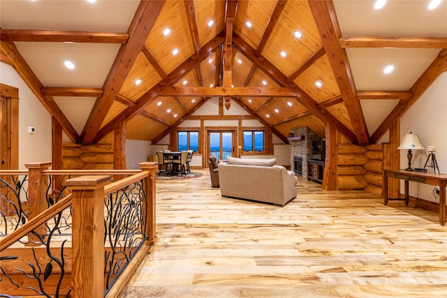 living room featuring vaulted ceiling with beams, log walls, and light wood-type flooring