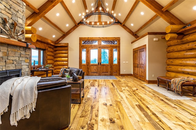 living room with a notable chandelier, hardwood / wood-style floors, beamed ceiling, log walls, and a stone fireplace