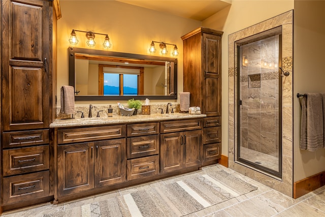 bathroom featuring a shower with door, tile patterned flooring, and dual bowl vanity