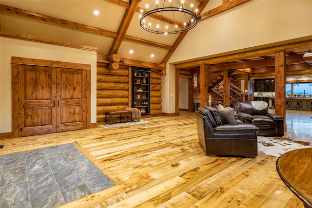 living room with vaulted ceiling with beams, a notable chandelier, and hardwood / wood-style floors