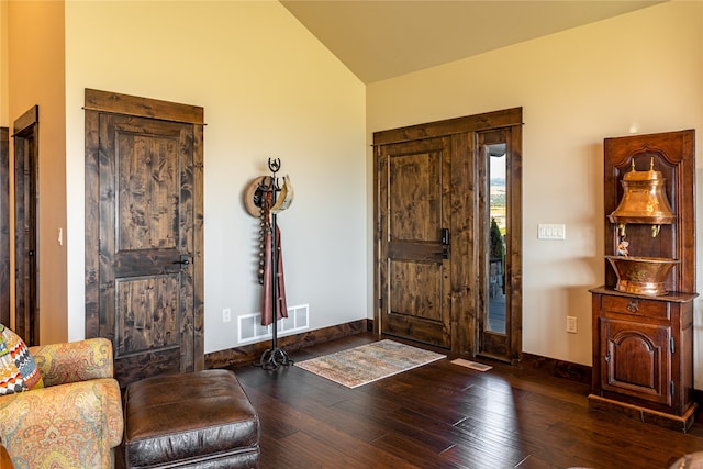 foyer with dark hardwood / wood-style floors and lofted ceiling