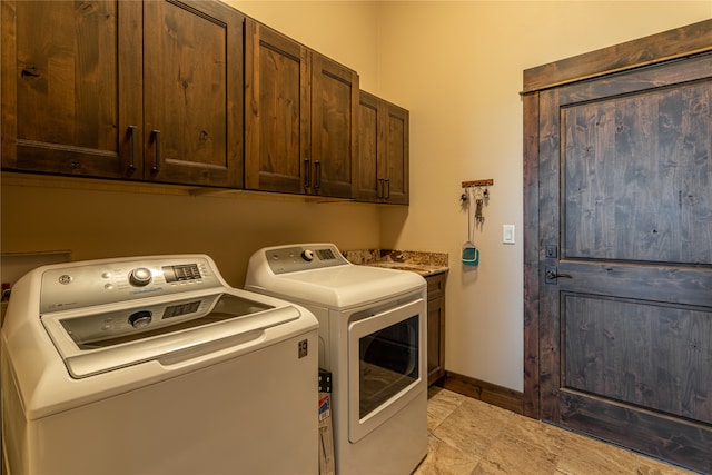 laundry room featuring cabinets, light tile patterned flooring, and washing machine and clothes dryer