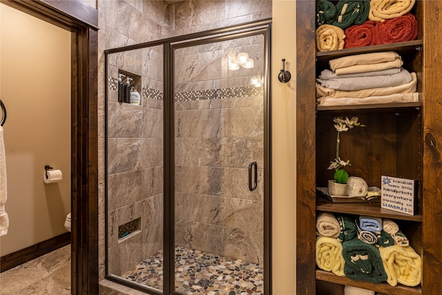 bathroom with a shower with shower door, toilet, and tile patterned flooring