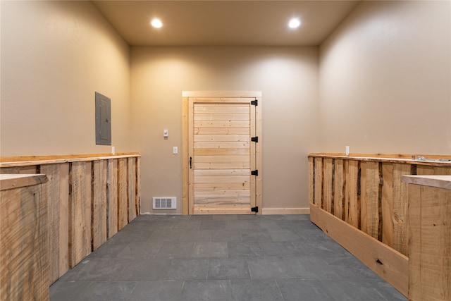 corridor featuring dark tile patterned floors and electric panel