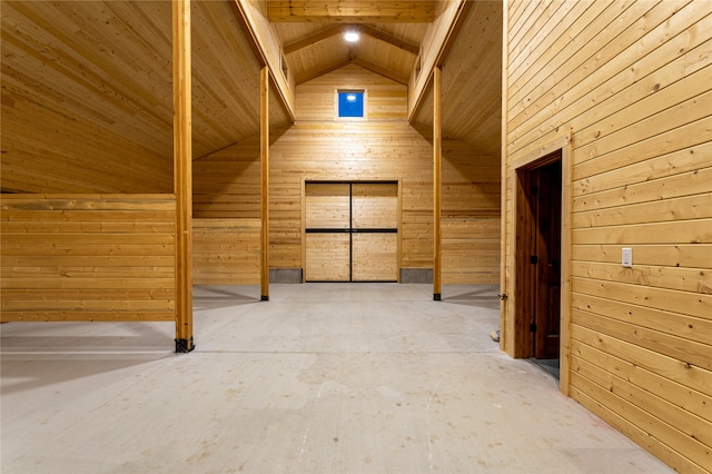 additional living space with wood ceiling, lofted ceiling with beams, and wooden walls