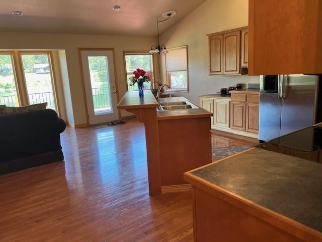5 Osprey Dr E, Thompson Falls, MT 59873 - kitchen featuring freestanding refrigerator, wood finished floors, a chandelier, a center island with sink, and lofted ceiling