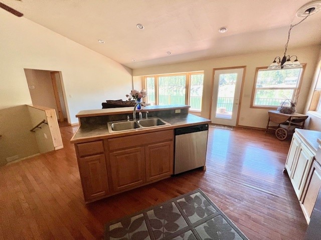 kitchen with an inviting chandelier, dishwasher, dark wood-type flooring, sink, and lofted ceiling