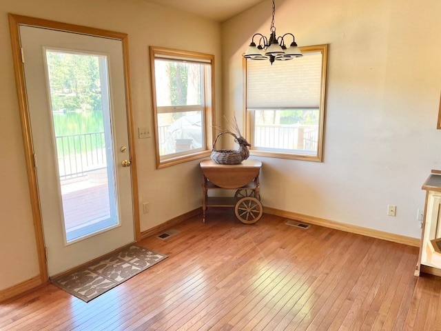 entryway with a notable chandelier and wood-type flooring