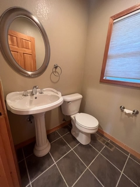 bathroom featuring tile flooring and toilet