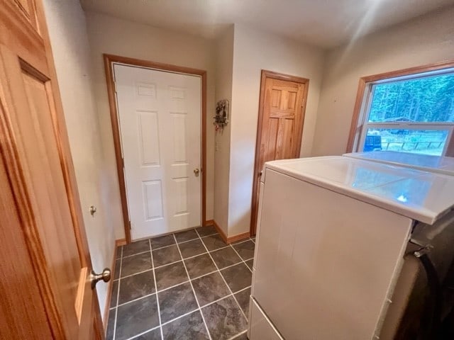 washroom featuring washer and clothes dryer and dark tile floors