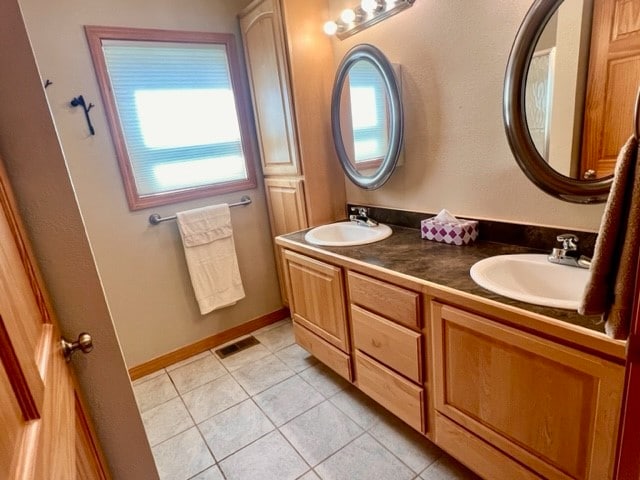 bathroom with tile flooring and dual bowl vanity