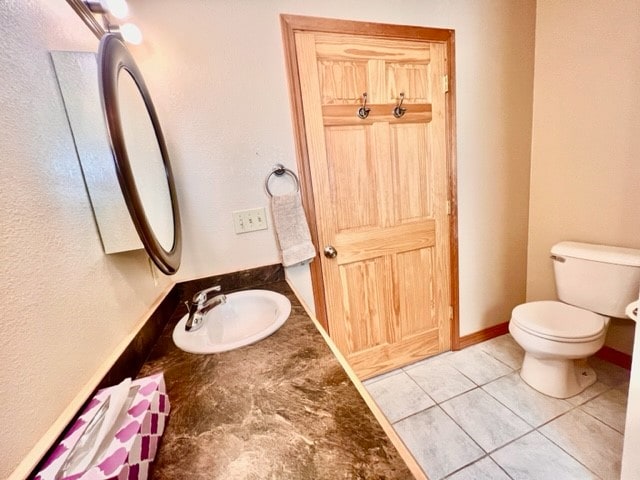 bathroom featuring tile floors, sink, and toilet