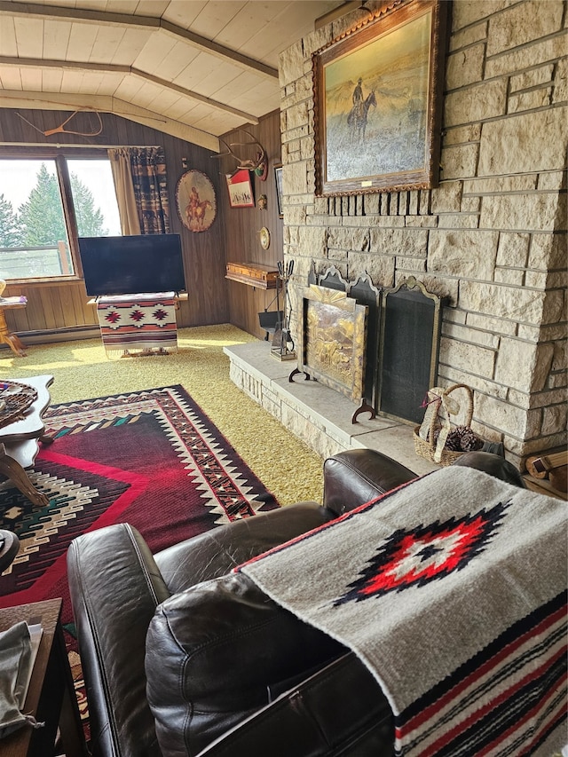 living room with lofted ceiling, wood walls, carpet flooring, and a stone fireplace