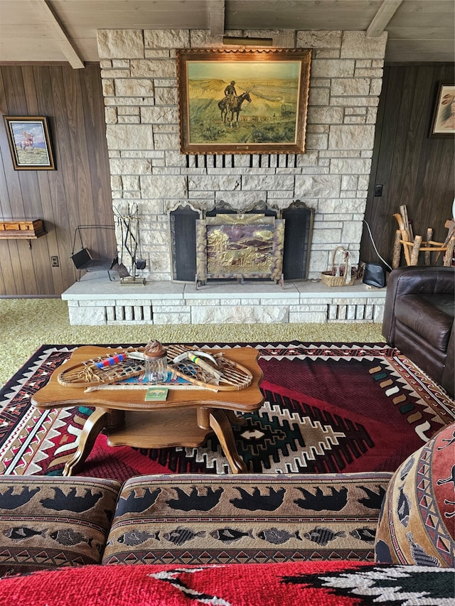 interior space with carpet, beamed ceiling, wood walls, and a fireplace