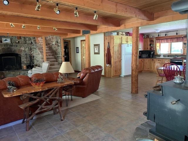 living room featuring sink, rail lighting, wooden ceiling, beamed ceiling, and a fireplace