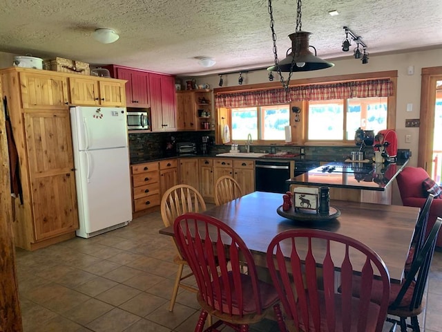 kitchen featuring black dishwasher, backsplash, white fridge, a textured ceiling, and light tile patterned floors