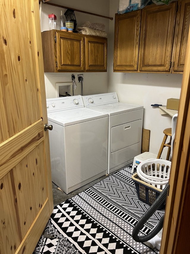 washroom with washer and dryer and cabinets