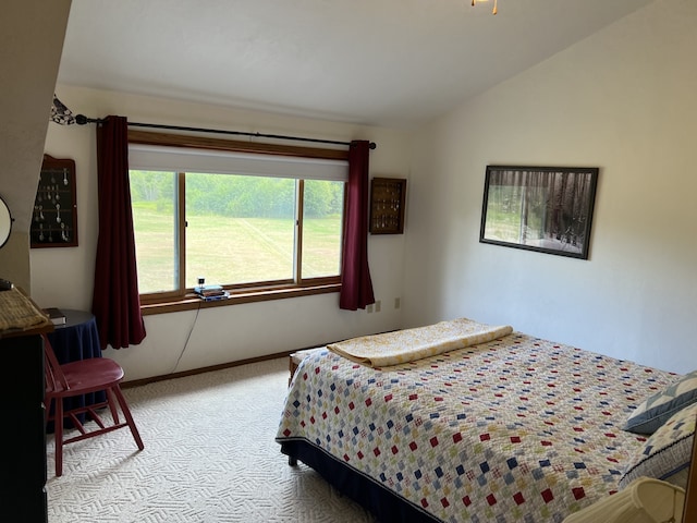 carpeted bedroom with lofted ceiling