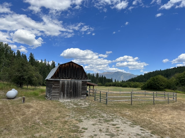 view of horse barn with a mountain view and a rural view