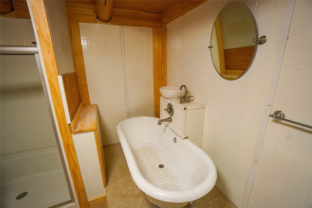 bathroom with tile walls, shower with separate bathtub, and tile flooring